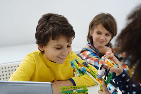 Coding Class, school girl constructing robot arm mechanism. multiethnic children making science,...