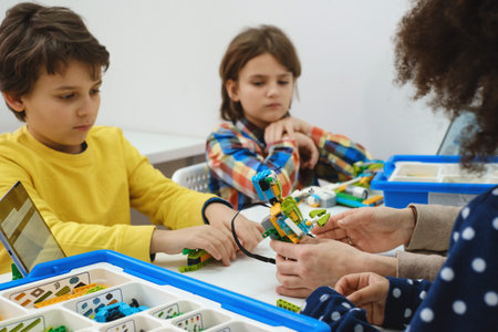 Students In School Computer Coding Class Building And Learning To Program Robot Vehicle. Multi...