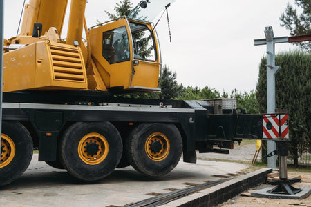 Construction crane lifting heavy freight. Modern mobile transportation technologies help building house. Real estate professional company working with big machines. Close-upの写真素材