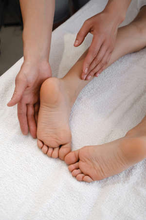 Child Foot massage treatment by professional massage therapist in spa resort. Wellness, stress relief and healthcare conceptの写真素材