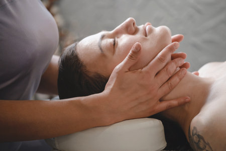 face massage with oil in traditional style made by professional beauty therapist women. anti-age massageの写真素材