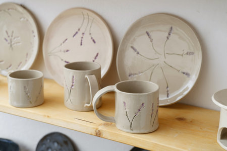 Ceramics with floral and natural patterns on the shelf of the shop. Creative minimalistic handmade...