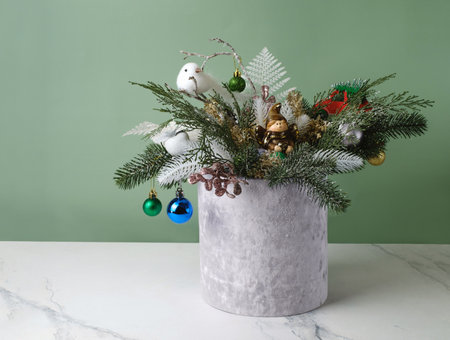 Christmas composition in velvet grey box with spruce, fern for table decoration. Snowy bunches with bobbles, bird in beautiful packaging, assembled by a florist. Floristic festive decor on the tableの写真素材