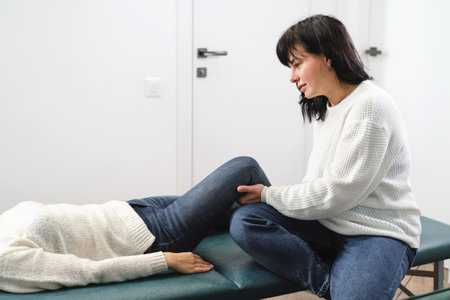 Knee therapy. Patient at the physiotherapy doing physical exercises with his therapist. rehabilitation center. Alternative treatment osteopath. Feldenkrais methodの写真素材