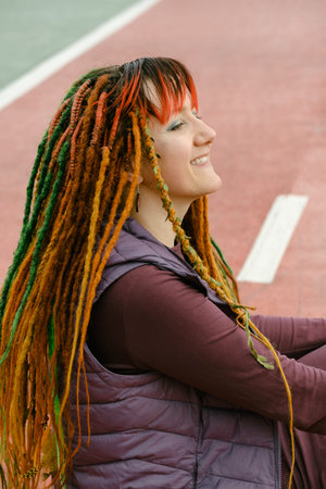 Funny free hipster Woman with dreadlocks on the road riding in the city at her 30s. female with...