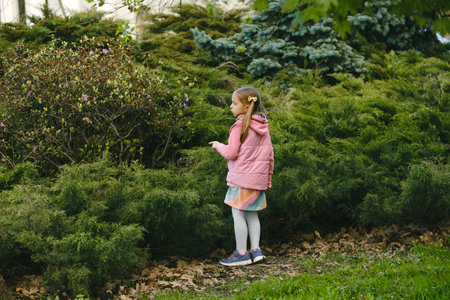 Scavenger hunt for kid in the park. Girl learning about environment. Natural education activity for World Earth day. Exploring in spring.の写真素材