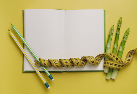 Asparagus and measuring tape isolated yellow. Diet and balanced nutrition food for weight loss conceptの写真素材