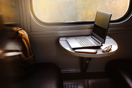 Working in train on sunset. Laptop standing on the table by the window. Nobody. Laptop computer...