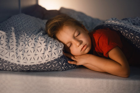 Child sleeping at night. Comfortable bed for kids. Toddler girl sleeping tight, fast falling asleep, healthy habits and comfortable beddingの写真素材