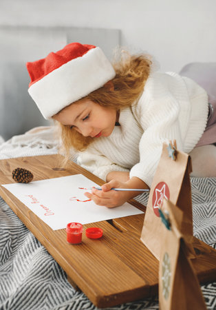 Family Christmas celebration, kid waiting for advent calendar present, writing letter Toddler girl excited about festive surprise in craft bag at home. Family celebration and preparation for New Yearの写真素材