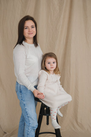 Portrait of a mother with toddler girl at home. Child and parent portrait in Scandinavian houseの写真素材