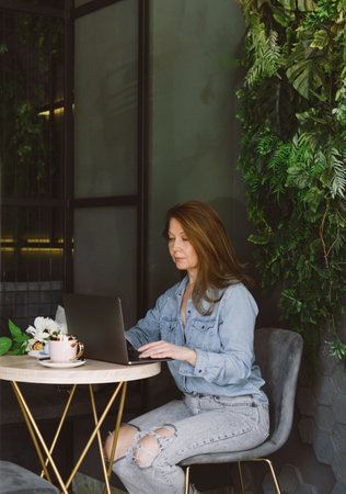 Woman working on laptop in cafeの写真素材