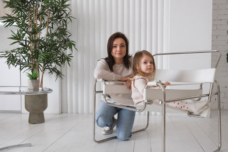 Portrait of mother with toddler girl at home. Child and parent portrait in Scandinavian houseの写真素材