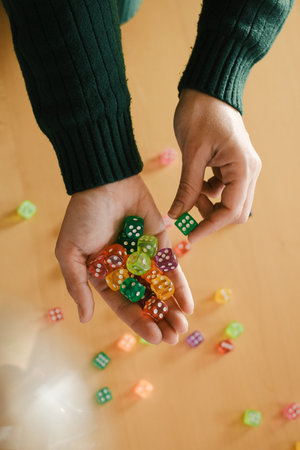 Female Player preparing for session of tabletop game. Dice in woman hands. Table games concept. Copy space. Gather vibrant dice in female hands, exciting leisure time with fortune and chanceの写真素材
