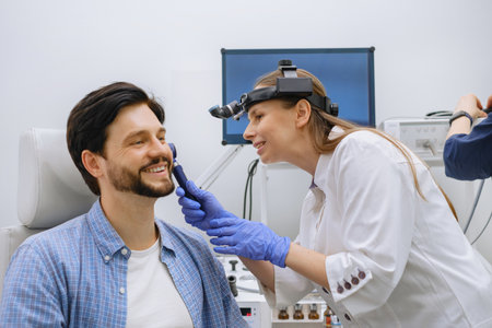 ear examination of male patient with otoscopeの写真素材