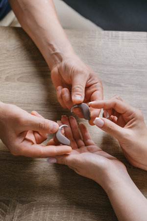 audiologist giving modern hearing aid for patient