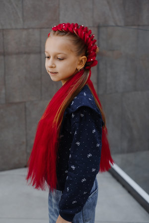 Young girl with red braided updo hairstyle featuring synthetic hair extensions