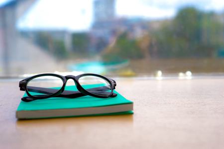 An eyeglasses lay over a green bookの写真素材