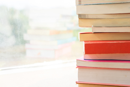 A pile of books lay over the table in the blur backgroundの写真素材