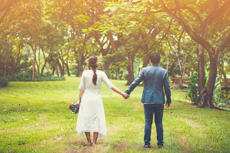 couple holding hands with sunlight  in gardenの写真素材