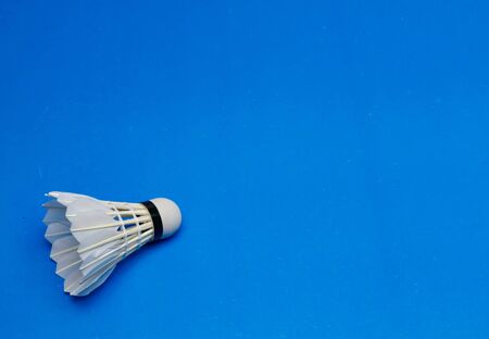 Shuttlecock  in the lower left corner, on blue background. copy space.の写真素材