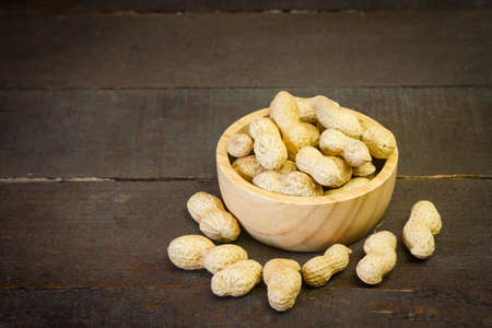 Peanuts on wooden bowl on wooden background.の写真素材