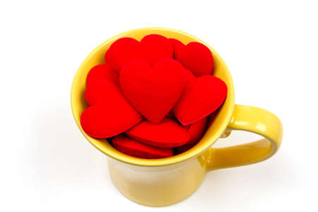Red heart in yellow cup ceramic isolated on white background. valentine's day concept.の写真素材