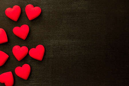 Valentine's day, Many red hearts on black wooden background, copy space, love concept.の写真素材