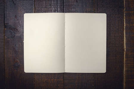 Open notebook on wooden background dark tone.の写真素材