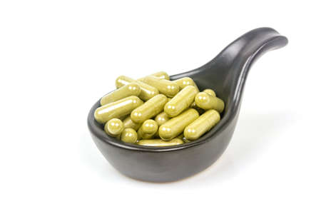 Close-up moringa oleifera capsule in black bowl ceramic isolated on white background.の写真素材