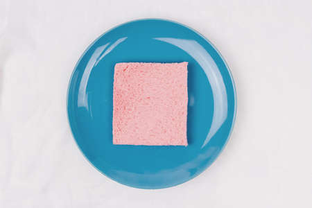 Top view of pink milk flavored sandwich bread on blue sky plate and white cloth background, soft warm tone, Beautiful breakfast concept.の写真素材