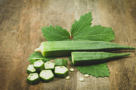 Fresh organic green okra and leaves on wooden dark tone.の写真素材
