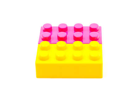 Pink and yellow plastic building block isolated on white background. Developmental toys for children.の写真素材