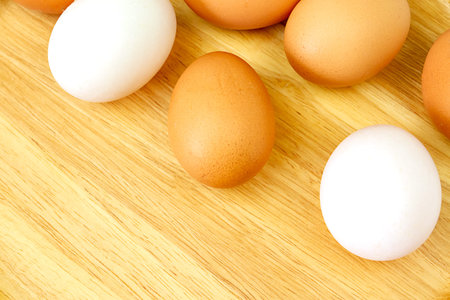 White and brown eggs on wooden background.の写真素材