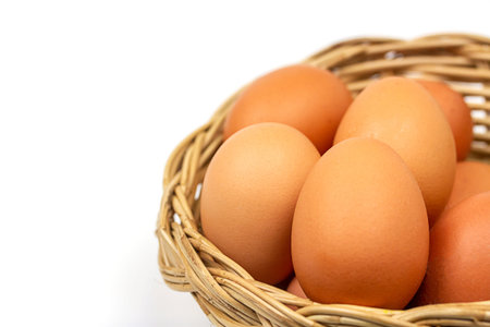 Eggs in basket isolated on white background.