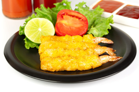 breaded shrimp on black plate isolated on white background