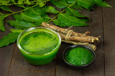 Neem leaf used as ayurvedic medicine with neem stick on wooden background.の写真素材