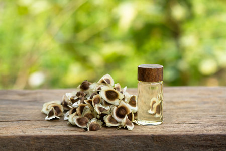 Oil of Moringa in bottle with seeds on wooden and blur background. Moringa oleifera tropical herb product concept.の写真素材