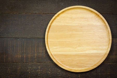 Empty wooden plate on rustic wooden background, top view.の写真素材