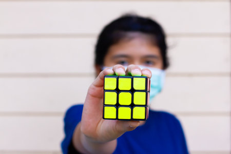 SAMUT-SAKHON, THAILAND - APRIL 02, 2021 : Hand holding rubik's cube of girl because she solved puzzle success.のeditorial素材
