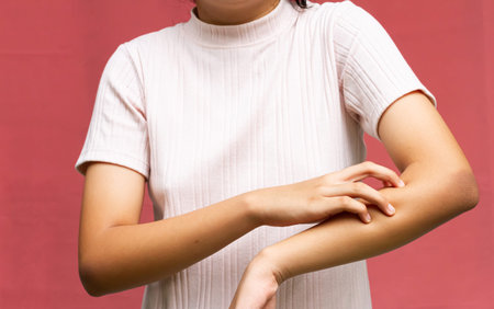 Young girl scratching hand herself. Allergy and skin diseases concept.