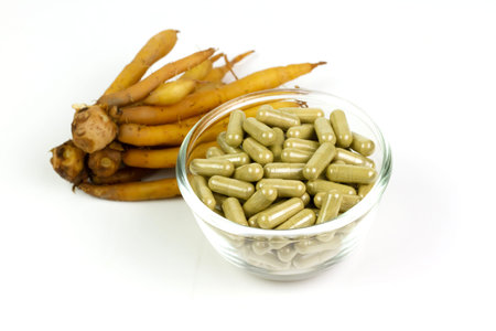 Finger root (Krachai) capsule in transparent bowl glass isolated on white background. The scientific...