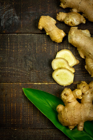 Fresh ginger and leaf on rustic wooden background, top view. The scientific name is zingiber officinale. Herbs for health care concept.の写真素材