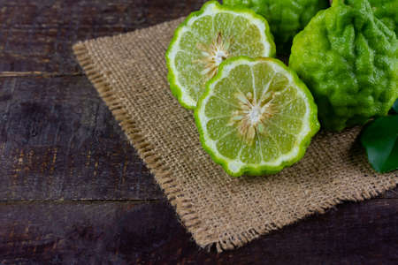 Bergamot fruit on sackcloth on wooden table. Bergamot is ingredient in food and is herb for body care.の写真素材