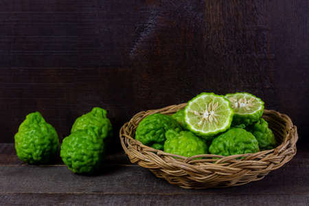 Bergamot fruit in wicker basket on wooden table. Bergamot is ingredient in food and is herb for body care.の写真素材