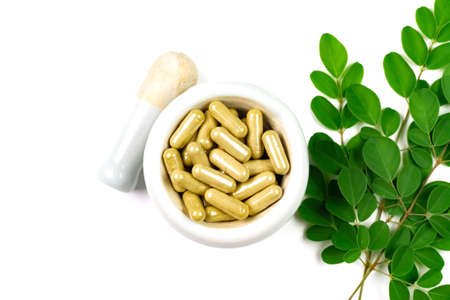 Moringa oleifera capsule on mortar and pestle with moringa leaf isolated on white background.の写真素材