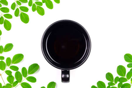 Moringa Tea in ceramic cup with fresh green leaf isolated on white background, top view. Moringa oleifera tropical herb healthy lifestyle concept.の写真素材