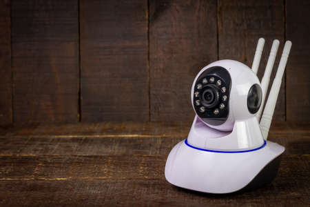 White IP Camera on wooden background. CCTV security camera for home or office.の写真素材