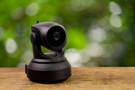 Black IP Camera on wooden with blur background. CCTV security camera for home or office.の写真素材
