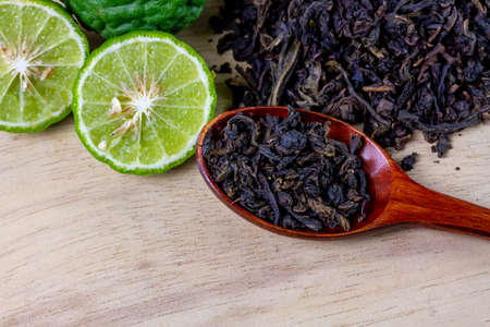 Bergamot tea or Earl Grey tea on wooden spoon and fresh bergamot fruit on wooden background.の写真素材